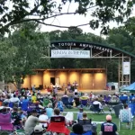 A group of people enjoying a concert at the Town Common in Greenville, NC